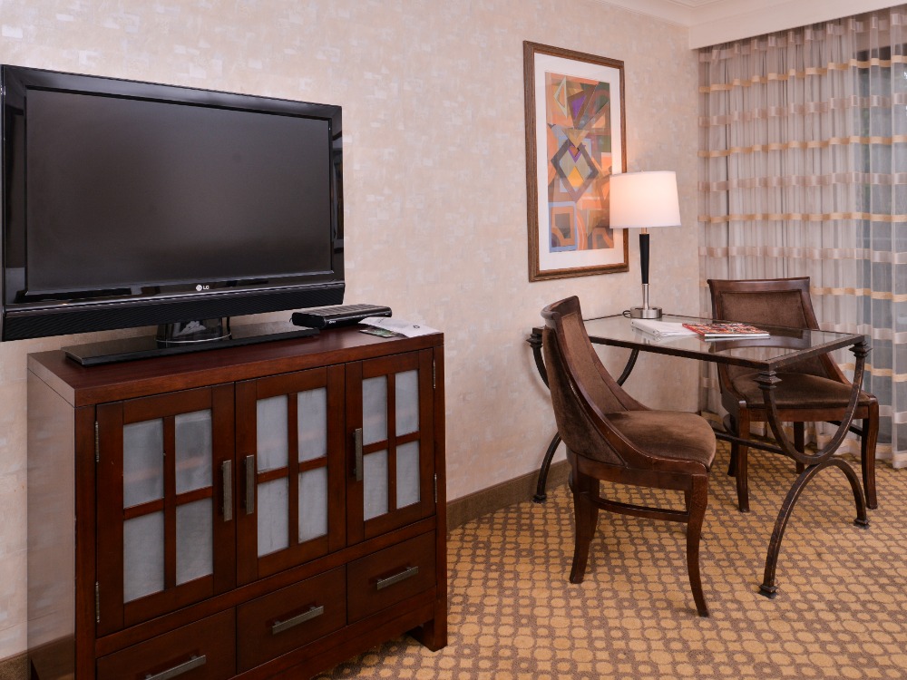 Hotel bedroom with TV and table